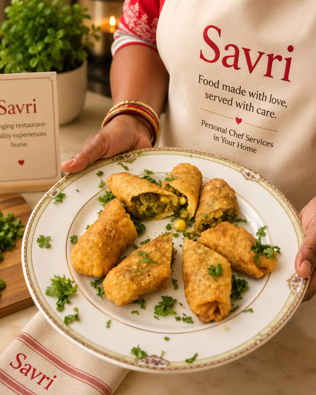A Savri chef plating samosas with the 'Food made with love' apron and card visible
